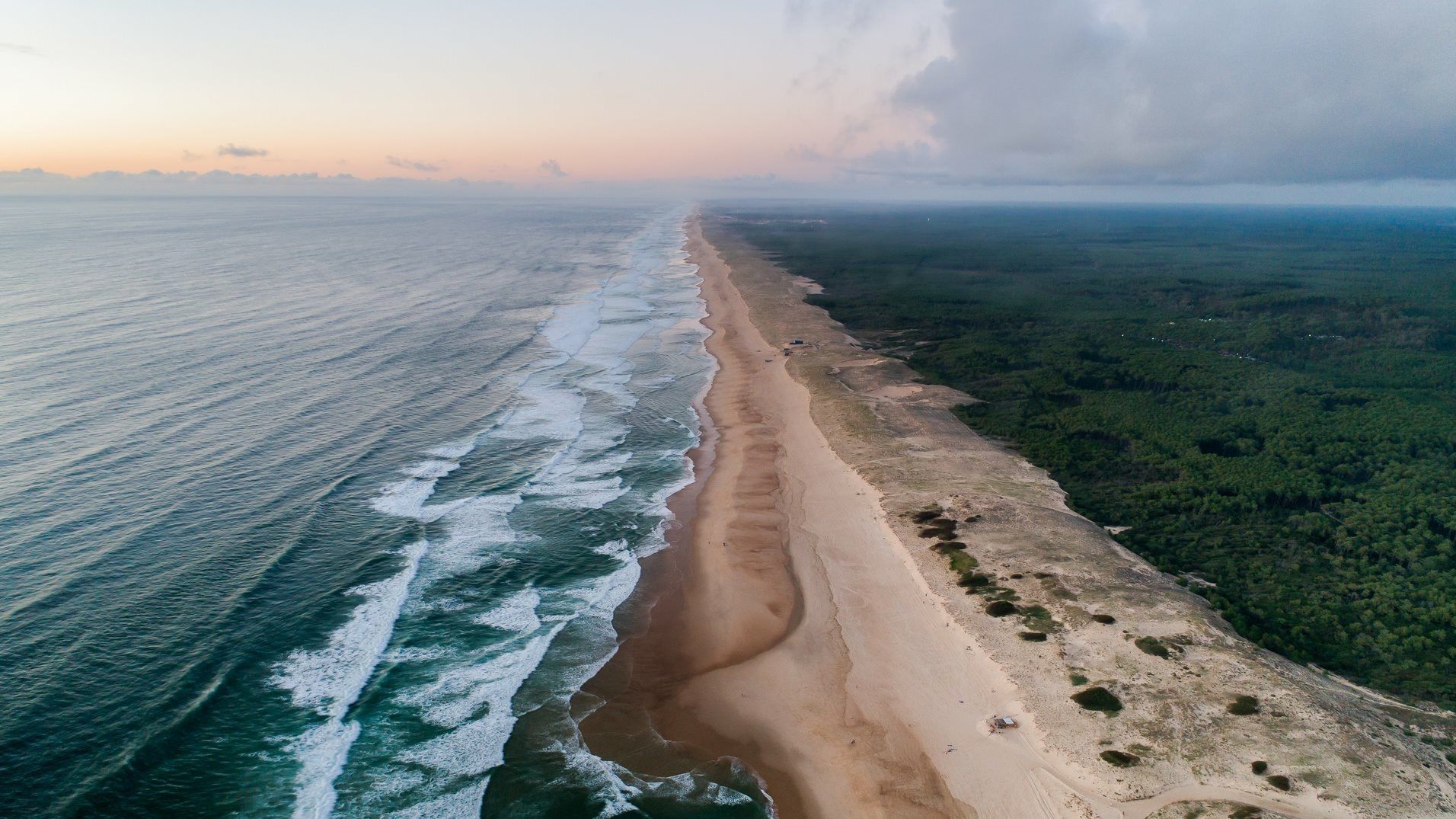 Vue aérienne de la côte landaise au coucher du soleil, l'océan rejoignant la plage et la forêt, près d'Hossegor